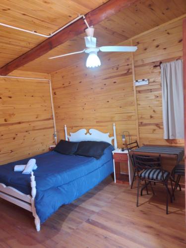 una camera con letto, ventilatore a soffitto e tavolo di D'Charrúas Cabañas Chajarí a Chajarí