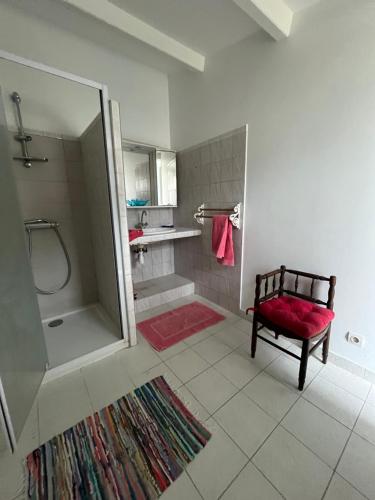 a bathroom with a shower and a bench and a red rug at Chez Frédérique in Saint-Pierre-dʼOléron