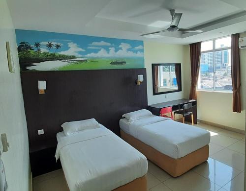 une chambre d'hôtel avec 2 lits et un tableau mural dans l'établissement Sipadan Inn Service Apartments Semporna, à Semporna