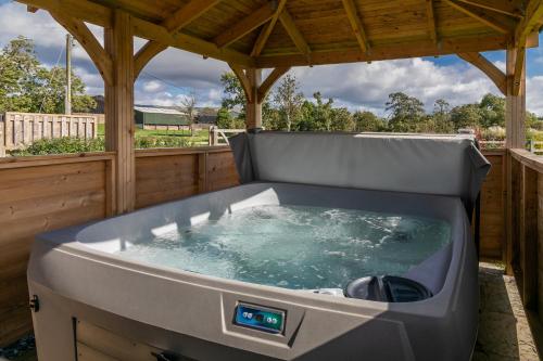 a large hot tub in a gazebo at Brockram Barn in Kirkby Stephen