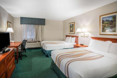 a hotel room with two beds and a flat screen tv at La Quinta by Wyndham Nashville Franklin in Franklin