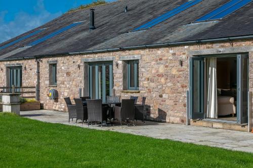 a patio with chairs and a table in front of a building at Brockram Barn in Kirkby Stephen