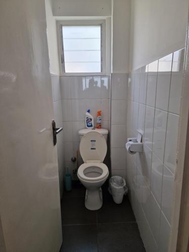a small bathroom with a toilet and a window at Sigma Theta Homes - KNUST Area in Kumasi
