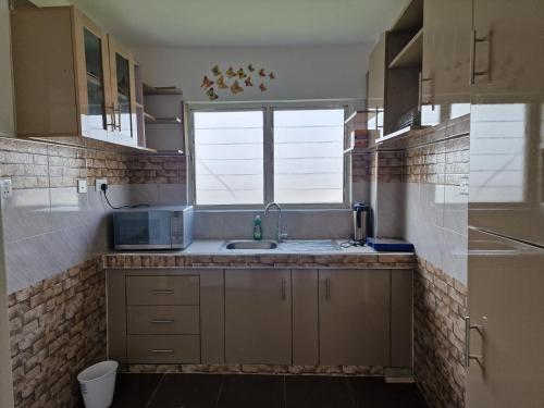 a kitchen with a sink and a window at Sigma Theta Homes - KNUST Area in Kumasi