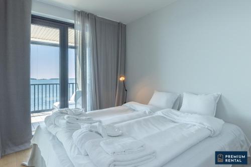 - une chambre avec 2 lits blancs et une grande fenêtre dans l'établissement Singel suite Floor 3, à Hanko
