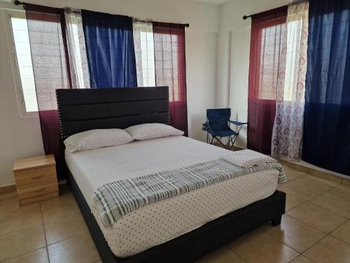 a bedroom with a bed in a room with windows at Sigma Theta Homes - KNUST Area in Kumasi