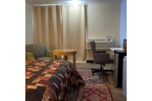 a bedroom with a bed and a desk and a chair at Lake Country Inn in Riverside