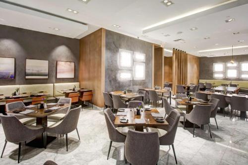 a restaurant with wooden walls and tables and chairs at Hyatt Regency John Wayne Airport Newport Beach in Newport Beach