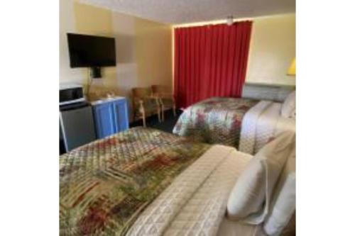 a hotel room with two beds and a television at Lake Country Inn in Riverside
