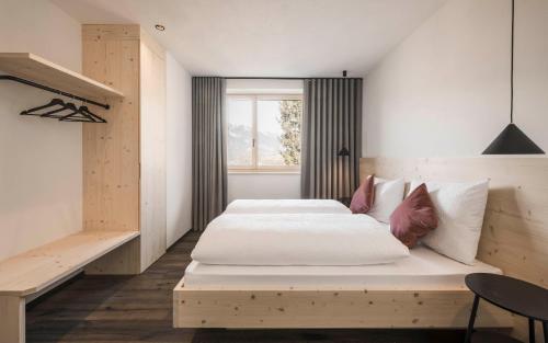 um quarto com uma grande cama branca e uma janela em Picea am Ötzerhof 2 em Merano