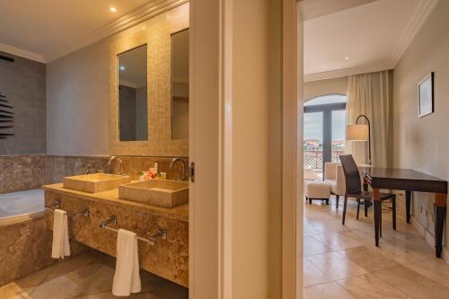 uma casa de banho com 2 lavatórios, uma banheira e uma mesa em Sports Illustrated Resorts Marina and Villas Cap Cana - All-Inclusive em Punta Cana