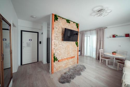 a living room with a brick wall with a tv on it at Exclusive Collection Palas Mall Suites and Studios in Iaşi