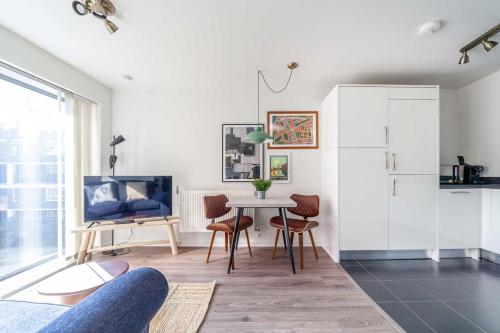 una sala de estar blanca con mesa y sillas en Cosy East London Retreat en Londres