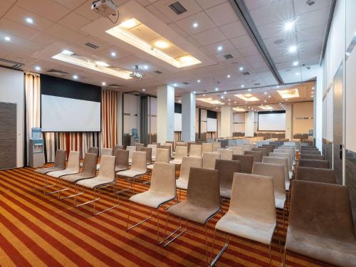 una sala conferenze con sedie e schermo di proiezione di Ibis Astana a Astana