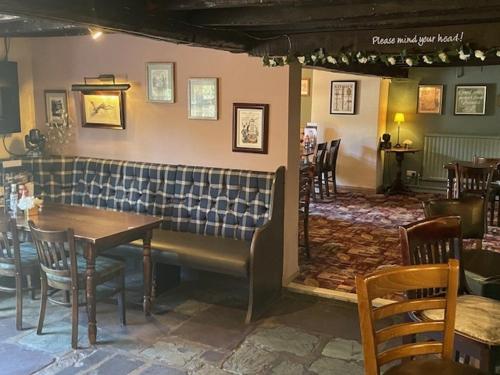 a restaurant with a table and chairs in a room at Chequers Country Inn in Lutterworth