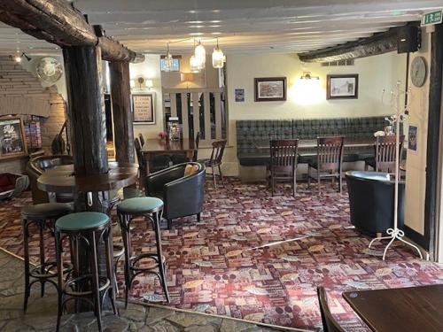 a bar with chairs and tables in a room at Chequers Country Inn in Lutterworth