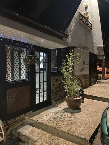 a front door of a building with a potted plant at Chequers Country Inn in Lutterworth
