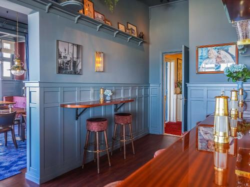 eine Bar in einem Restaurant mit blauen Wänden und Stühlen in der Unterkunft Boulevard Hotel Scheveningen in Scheveningen