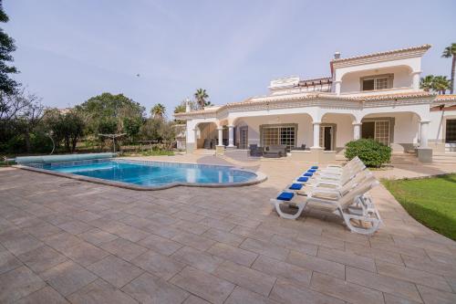 a house with a swimming pool and two lounge chairs at Villa Luxury Suites, Heated Outdoor Pool in Portimão