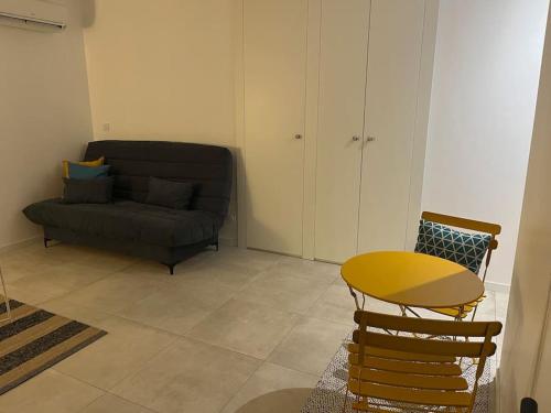 een woonkamer met een bank en een tafel bij Charmant Studio / Centre ville in Niort