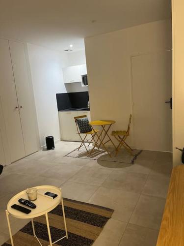 een woonkamer met een tafel en een keuken bij Charmant Studio / Centre ville in Niort