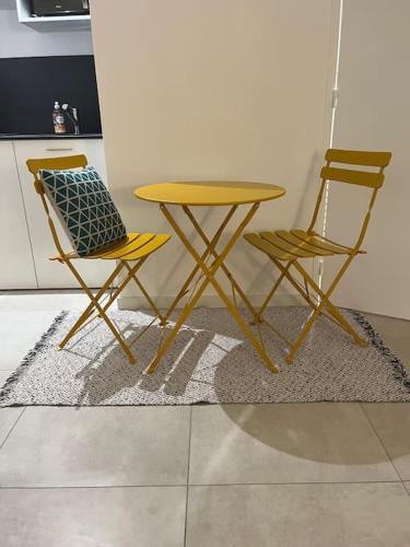 een gele tafel en twee stoelen in een keuken bij Charmant Studio / Centre ville in Niort