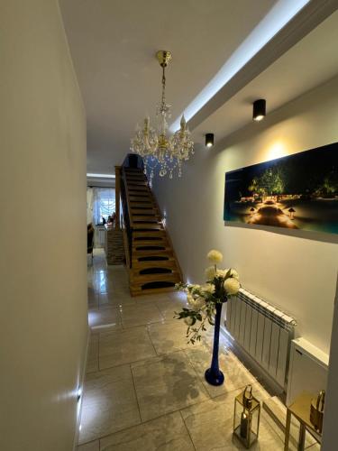 um corredor com uma escada e um vaso com flores em Pokoje Gościnne u Reni em Wambierzyce