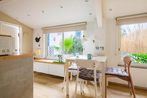 une cuisine avec une table et des chaises et une cuisine avec une fenêtre dans l'établissement Petite maison-studio Ba014s, à Cagnes-sur-Mer