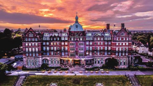a large building with a sunset in the background at DoubleTree by Hilton Harrogate Majestic Hotel & Spa in Harrogate