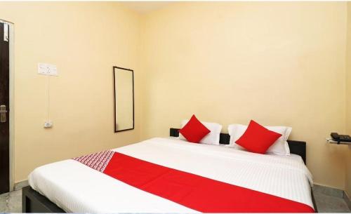 - une chambre avec un grand lit blanc et des oreillers rouges dans l'établissement MOSS GUEST HOUSE, à kolkata