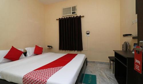 - une chambre avec un grand lit et des oreillers rouges dans l'établissement MOSS GUEST HOUSE, à kolkata