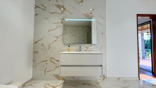 een badkamer met een witte wastafel en een spiegel bij Casa Loureiro de Baixo in Loureiro