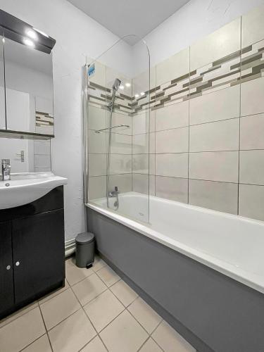 une salle de bain avec une baignoire et un lavabo dans l'établissement Échappée Belle à Épinal, à Épinal