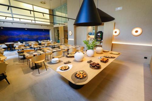 a restaurant with a long table with food on it at Hotel Zenit Bilbao in Bilbao