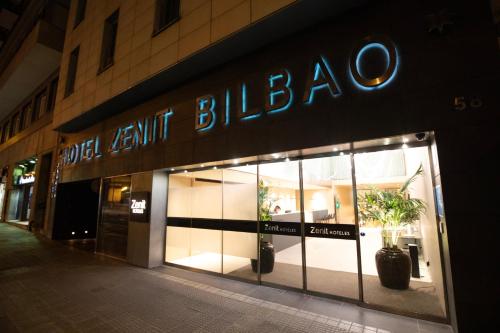 una tienda frente a un edificio con un cartel. en Hotel Zenit Bilbao en Bilbao