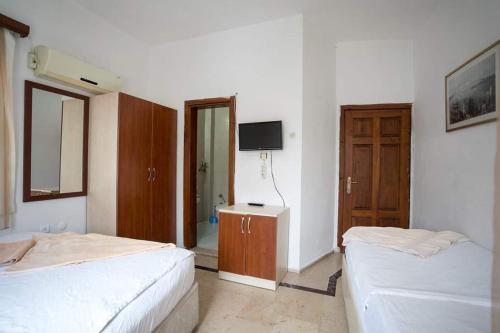a bedroom with two beds and a television in it at Dedehan Pansiyon in Antalya
