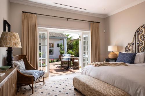 um quarto com uma cama e uma porta de vidro deslizante em La Fontaine Guest House Hermanus em Hermanus