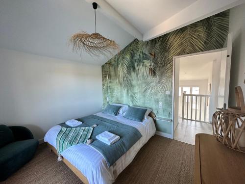 une chambre avec un lit avec un tableau sur le mur dans l'établissement Un air de paradis, à Gujan-Mestras