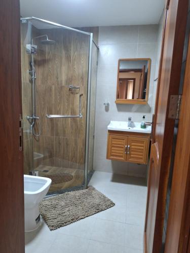 a bathroom with a shower and a toilet and a sink at Sabra Palmvillage mikocheni in Dar es Salaam