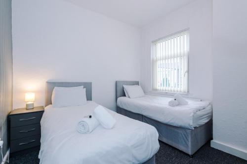 two beds in a room with a window at 2 Bedroom | Central location in Saint Helens
