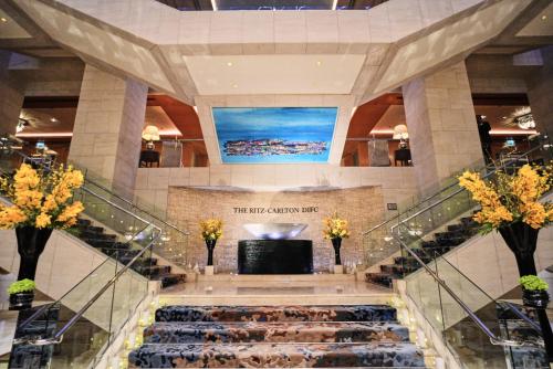 ドバイにあるRitz Carlton Residences DIFC Downtown Dubaiのテレビ付きの建物内の螺旋階段