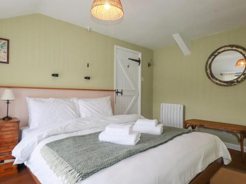 a bedroom with a white bed with towels on it at Waterside Cottage in Truro