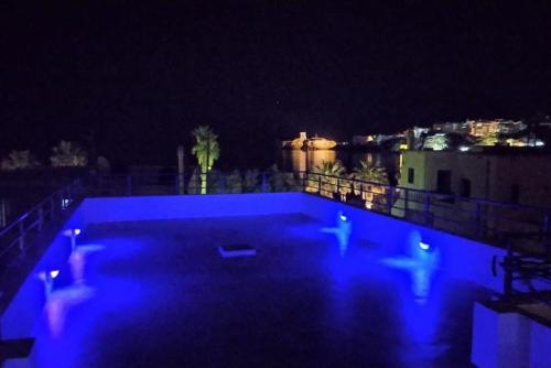 a swimming pool at night with blue lights at The house of Nikos and Katerina 2 in Andros