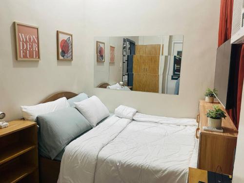 um quarto com uma cama e um espelho grande em Cozy 1BR Unit with Full Bathroom,Kitchen, Wifi at Sonia's Island Stay em Virac
