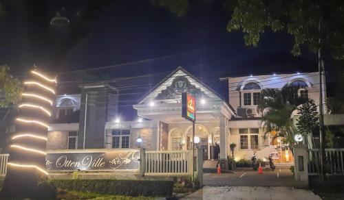 a white house with a sign in front of it at night at Cove Ottenville Boutique Hotel in Bandung