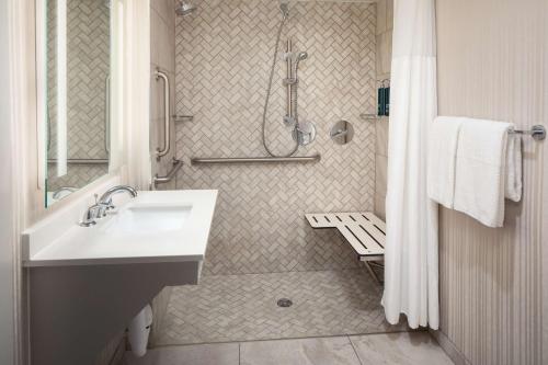 uma casa de banho com um lavatório e um chuveiro em DoubleTree by Hilton Silver Spring Washington DC North em Silver Spring
