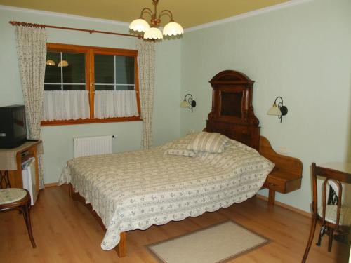 a bedroom with a bed and a table and a window at Bundi Vendégház in Kehidakustány