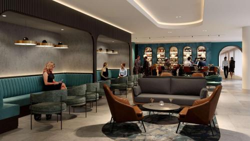 a lobby of a restaurant with chairs and a bar at Hyatt House London Stratford - Aparthotel in London