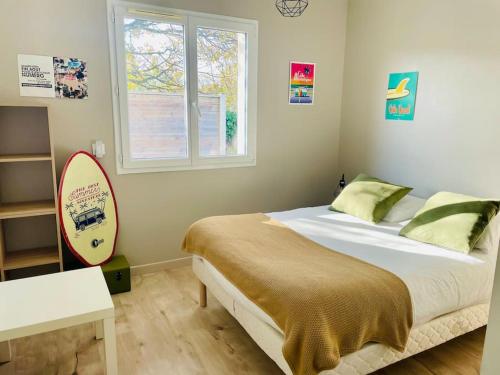 - une chambre avec un lit et une planche de surf dans l'établissement Villa jardin clos - piscine & jacuzzi privatif - animaux acceptés, à Gujan-Mestras