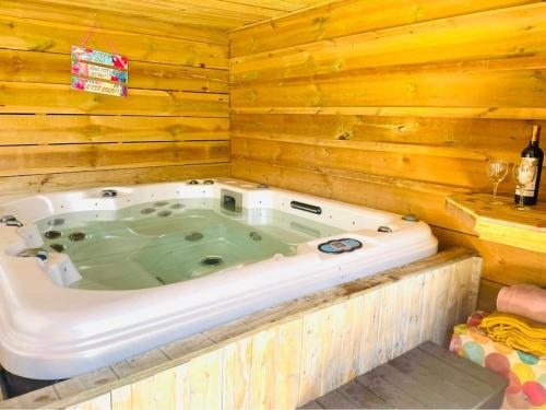 une baignoire jacuzzi dans une cabane en rondins dans l'établissement Villa jardin clos - piscine & jacuzzi privatif - animaux acceptés, à Gujan-Mestras
